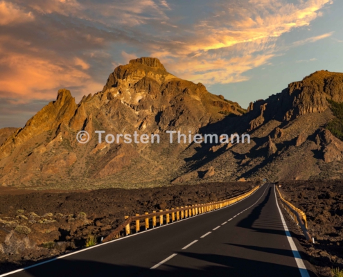 Highway-1 Abendstimmung in der Caldera auf La Palm. Berge im Hintergrund. Landstraße diagonal durchs Bild.