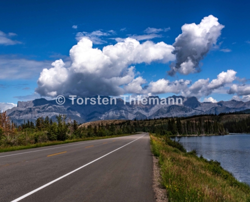 Highway-2 Icefield Parkway Landstraße in Kanada. Berge im Hintergrund. Blauer Himmel mit weißen Wolken.
