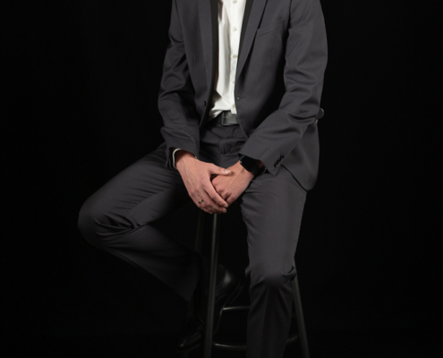 Businessportraits von einem jungen Mann vor schwarzem Hintergrund
