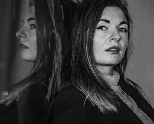 Portraitsaufnahmen in schwarzweiß von einer jungen Frau mit lagen dunklen Haaren