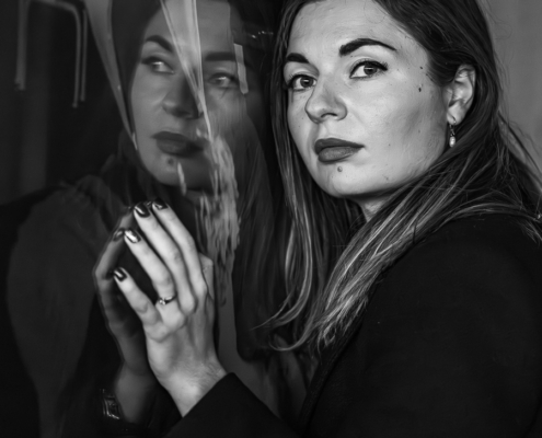 Portraitsaufnahmen in schwarzweiß von einer jungen Frau mit lagen dunklen Haaren