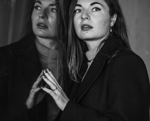 Portraitsaufnahmen in schwarzweiß von einer jungen Frau mit lagen dunklen Haaren