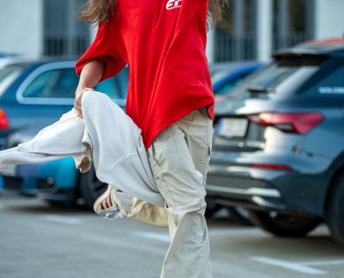 Modeaufnahmen einer jungen, asiatisch wirkenden Frau mit rotem Shirt und langen dunklen Haaren, welche auf mich zu rennt.